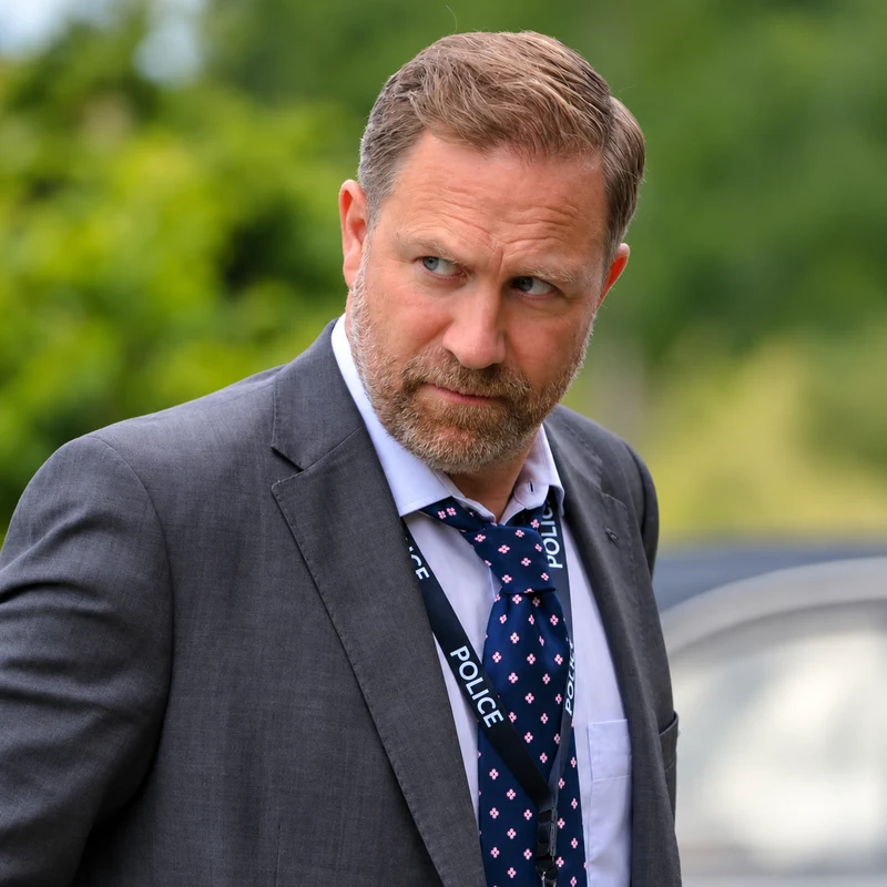 Phill Langhorne como DS Brendan Perry en El club del crimen de Marlow